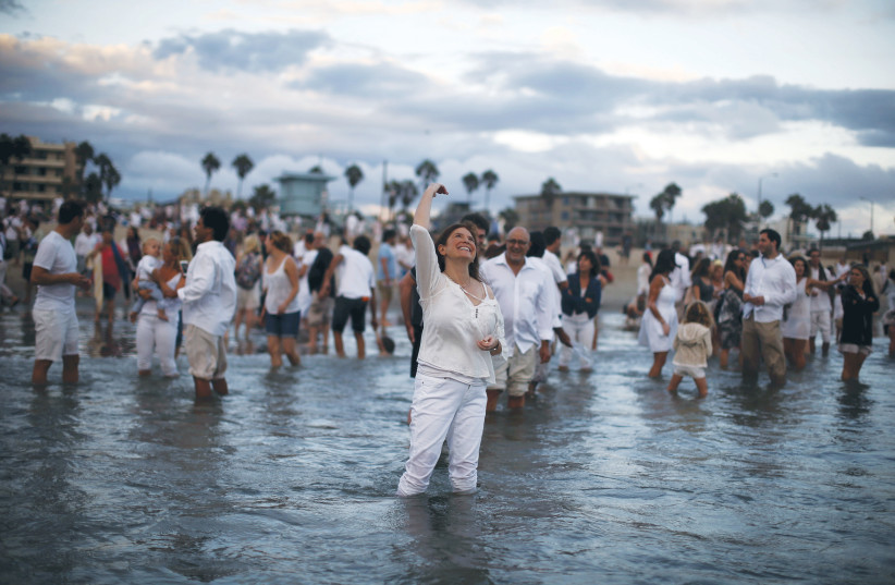  RABBI NAOMI LEVY throws bread crumbs into the Pacific Ocean at the Nashuva Spiritual Community Jewish New Year celebration in Los Angeles, per the Jewish custom to symbolically cast away sins. (photo credit: Lucy Nicholson/Reuters)