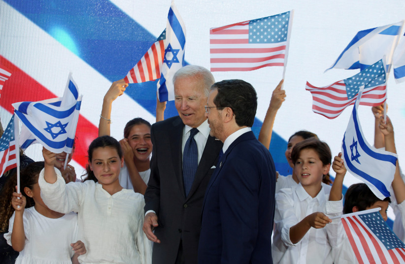  Children waving flags as US President Joe Biden arrives to meet Israeli President Isaac Herzog at his residence in Jerusalem, July 14, 2022 (credit: REUTERS/EVELYN HOCKSTEIN)