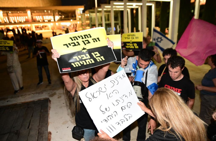 A Crime Minister holds up a poster reading ''Netanyahu is Ben Gvir, Ben Gvir is Netanyahu'' while a pro-Benjamin Netanyahu protestor holds up a poster reading ''Israel is only the nation of the Jewish people.'' (credit: AVSHALOM SASSONI/MAARIV)