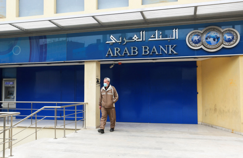  A man walks in front of closed Arab Bank branch on the first day of a two-day banks strike in Sidon, Lebanon March 21, 2022 (credit: AZIZ TAHER/REUTERS)