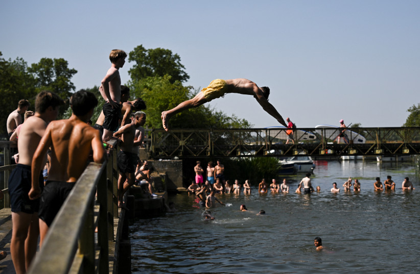 A man dives into River Thames, during a heatwave in Oxford, Britain, July 19, 2022. (photo credit: REUTERS/DYLAN MARTINEZ)
