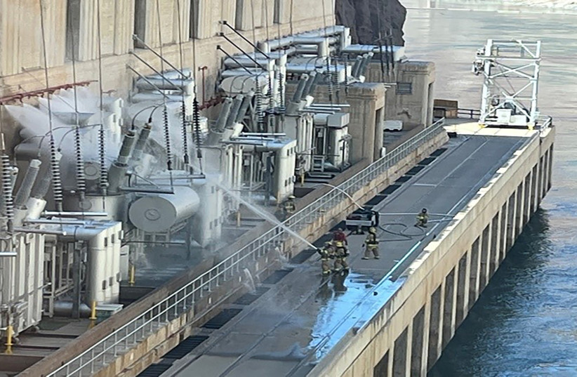  Firefighters pour water on electrical transformer equipment at the Hoover Dam near Boulder City, Nevada, US July 19, 2022. (photo credit: Bureau of Reclamation/Handout via REUTERS.)