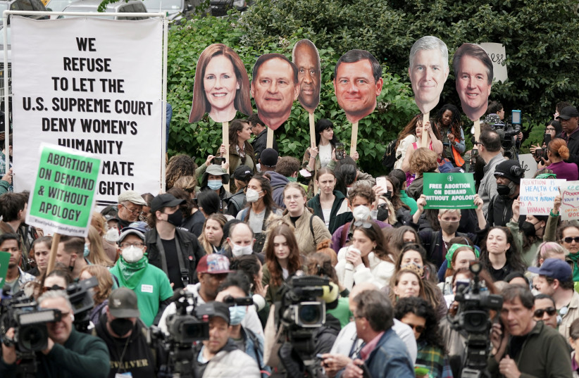  Pro-abortion demonstrators hold up photographs of U.S. Supreme Court Associate Justice Amy Coney Barrett, Associate Justice Samuel Alito, Associate Justice Clarence Thomas, Associate Justice Brett Kavanaugh and Chief Justice John Roberts during a protest in Foley Square, May 3, 2022 (credit: REUTERS/JEENAH MOON)