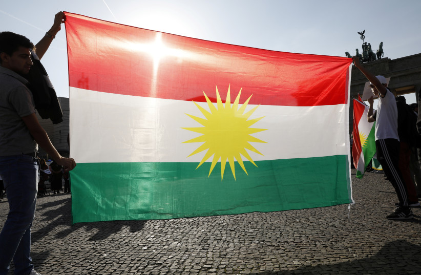  Protesters hold a Kurdish flag during a rally against the Turkish military operation in Syria, in Berlin, Germany, October 14, 2019 (credit: MICHELE TANTUSSI/REUTERS)