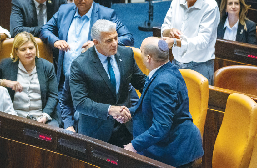 PRIME MINISTER Yair Lapid and Alternate Prime Minister Naftali Bennett exchange their seats at the government table in the Knesset plenum last month, after the vote to disperse parliament, as Lapid was becoming prime minister and Bennett taking the title of alternate prime minister. (credit: OLIVIER FITOUSSI/FLASH90)