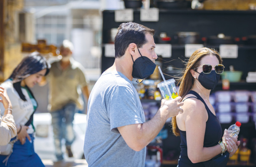  SOME PEOPLE wear masks, others don’t, at the Mahaneh Yehuda market in Jerusalem, earlier this month. In the post-COVID-19 reality, we will be tasked with addressing the scar tissue that developed over the last two years, says the writer.  (photo credit: OLIVIER FITOUSSI/FLASH90)