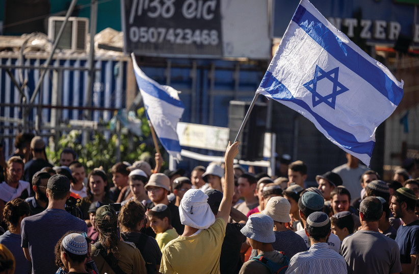  Settlers from the Nahala Settlement Movement beginning to march from the Gush Etzion junction on their way to establish illegal outposts on Wednesday,  and, on the right, Israeli and Palestinian detractors protesting the action. (photo credit: YONATAN SINDEL/FLASH90)