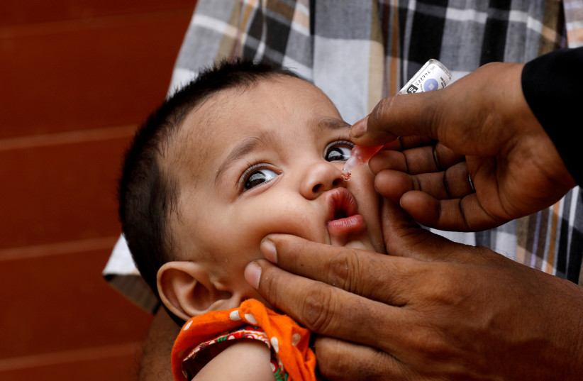  A girl receives polio vaccine drops, during an anti-polio campaign, in a low-income neighborhood as the spread of the coronavirus disease (COVID-19) continues, in Karachi, Pakistan July 20, 2020. (credit: REUTERS/AKHTAR SOOMRO)