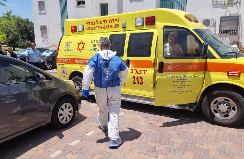  An ambulance is seen parked outside the apartment building where a man killed his daughter and himself. (photo credit: ISRAEL POLICE SPOKESPERSON'S UNIT)