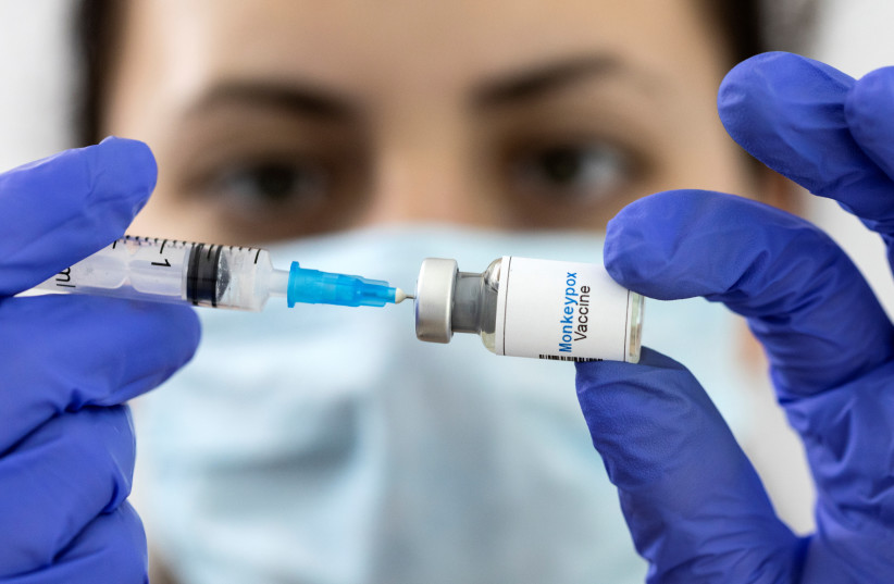  Illustration shows a woman holding a mock-up vial labeled "Monkeypox vaccine" and medical syringe (photo credit: REUTERS/DADO RUVIC/ILLUSTRATION)