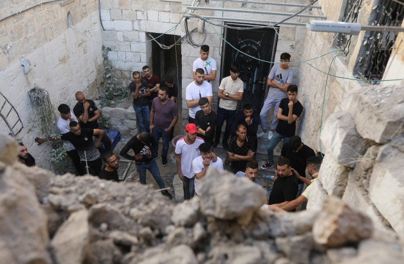  People gather at the scene where two Palestinian militants were killed during clashes with Israeli forces in a raid, in Nablus, West Bank, July 24, 2022 (photo credit: REUTERS/RANEEN SAWAFTA)
