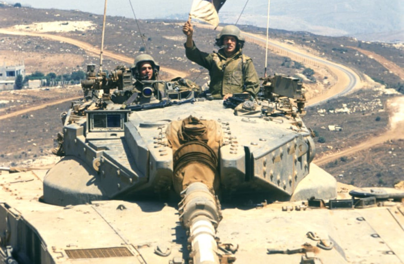  An IDF soldier is seen waving an Israeli flag from within a tank at the start of Operation Accountability. (photo credit: Wikimedia Commons)