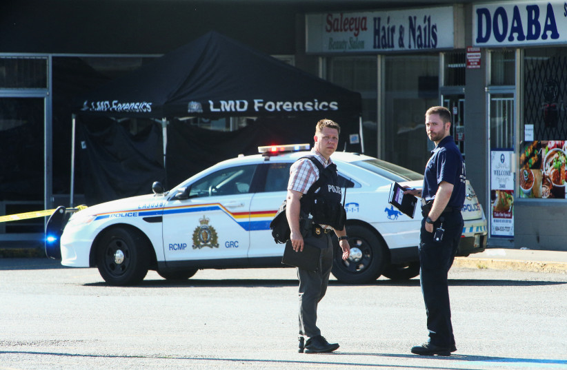 Police officers stand near a crime scene after authorities alerted residents of multiple shootings targeting transient victims in the Vancouver suburb of Langley, British Columbia, Canada, July 25, 2022. (credit: REUTERS/Jesse Winter)