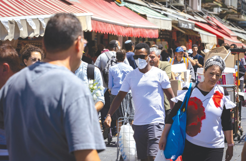  PEOPLE OF different sorts walk through the Mahaneh Yehuda market, in Jerusalem. Before we can truly address the threat of antisemitism, we need to confront the hatred we harbor for one another, says the writer.  (photo credit: OLIVIER FITOUSSI/FLASH90)