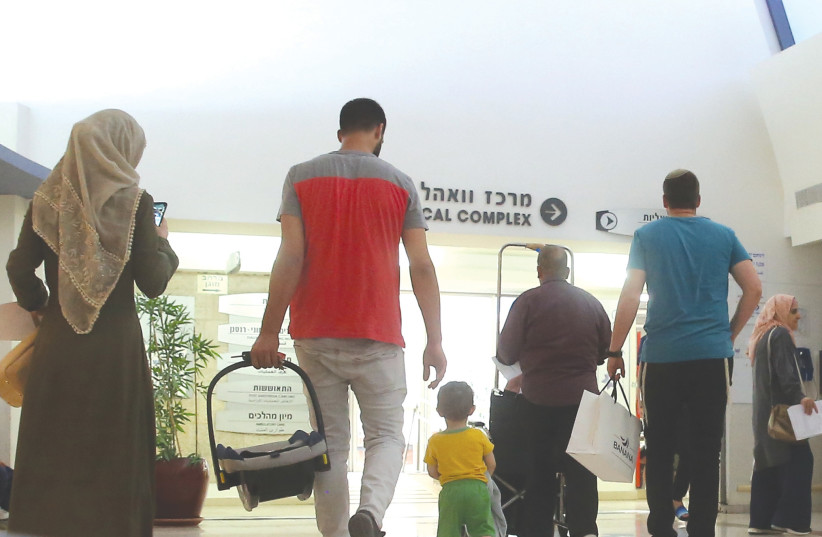  PART OF the medical care coexistence at Shaare Zedek Medical Center in Jerusalem, as a Muslim family and a man wearing a kippah are among those walking through the corridors.  (photo credit: EZRA LANDAU)
