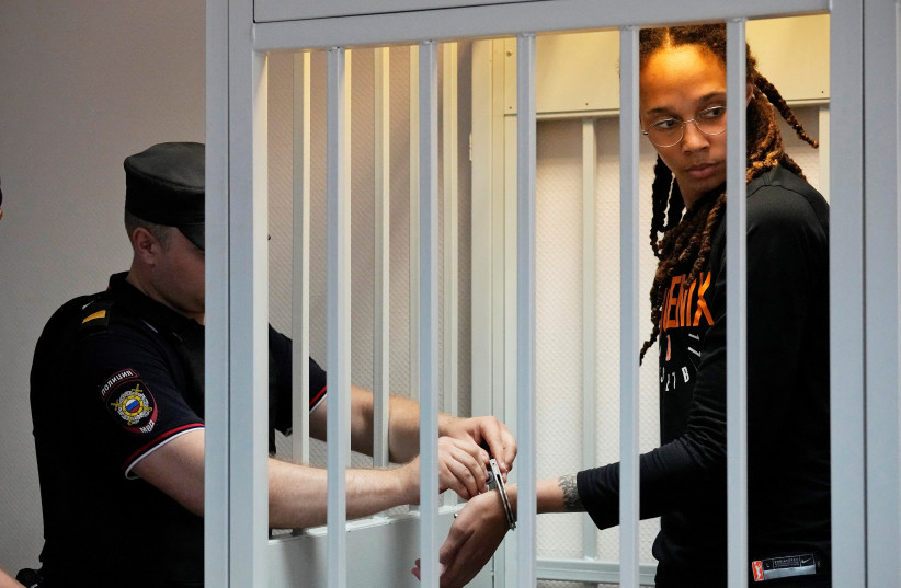  A policeman removes the handcuffs from WNBA star and two-time Olympic gold medalist Brittney Griner in a courtroom prior to a hearing, in Khimki, outside Moscow, Russia, July 27, 2022.  (photo credit: ALEXANDER ZEMLIANICHENKO/POOL VIA REUTERS)