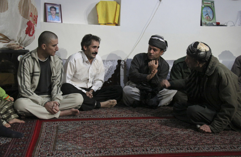  Hajeer Ebrahimi (L) and Bakhtiyar Memari (2nd L) talk to relatives of their victims in a home in the northwestern city of Marivan, near the Iranian border with Iraq, in this undated handout (credit: REUTERS/PRESS TV/HANDOUT)