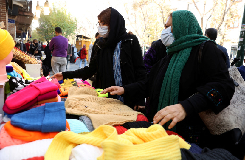 Women shop in a street in Tehran, Iran, November 29, 2021. (photo credit: Majid Asgaripour/WANA (West Asia News Agency) via REUTERS/File Photo)