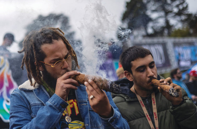  A MAN tokes up during the 420 Hippie Hill festival, as marijuana enthusiasts mark the annual but informal cannabis holiday at San Francisco’s Golden Gate Park, in April (Illustrative of the wild 1960s). (photo credit: Carlos Barria/Reuters)