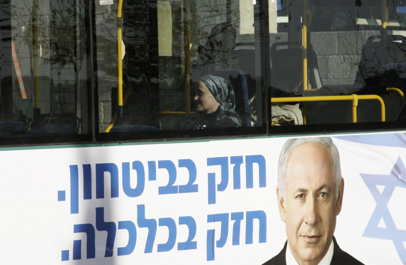  A bus drives through Jerusalem with a large election poster of Likud Party says "strong in security, strong in economy". Jan 27, 2009 (photo credit: KOBI GIDEON/FLASH90)