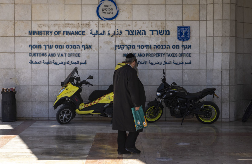  People walk outside the Tax Authorities offices in Jerusalem on July 27, 2022 (credit: OLIVIER FITOUSSI/FLASH90)