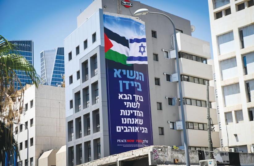  A PEACE NOW banner in Tel Aviv earlier this month welcomes US President Joe Biden, with the Israeli and Palestinian flags, and the words “Welcome to the two countries we love the most.” (photo credit: AVSHALOM SASSONI/FLASH90)