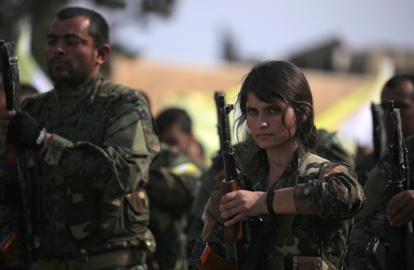  A fighter of Syrian Democratic Forces (SDF) holds her weapon as they announce the destruction of Islamic State's control of land in eastern Syria, at al-Omar oil field in Deir Al Zor, Syria on March 23, 2019 (credit: REUTERS/RODI SAID)
