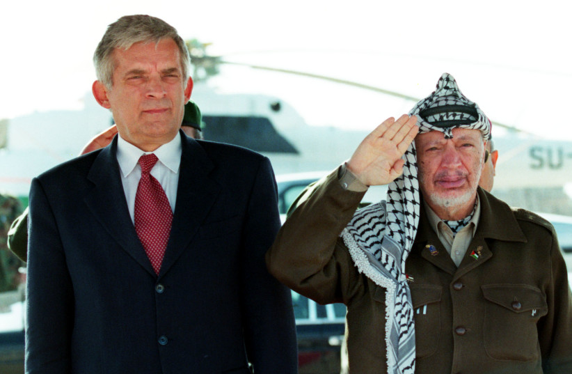  Polish Prime Minister Jerzy Buzek stands to attention next to saluting Palestinian President Yasser Arafat as national anthems are played December 9 during a welcoming ceremony for the visiting Polish leader outside Arafat's West Bank headquarters, December 9, 1999.  (credit: JWH/AA)