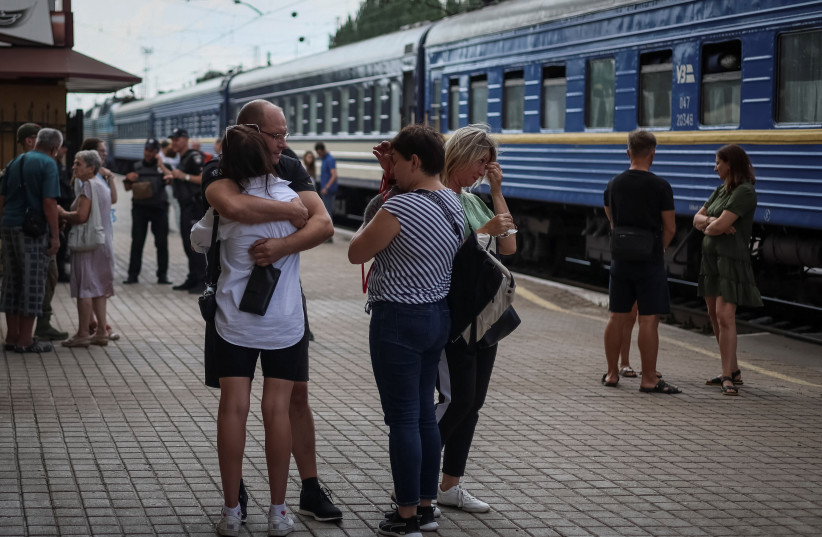 People say goodbye as they board a train to Dnipro and Lviv during an evacuation effort from war-affected areas of eastern Ukraine, amid Russia's invasion of the country, in Pokrovsk, Donetsk region, Ukraine, July 20, 2022. (photo credit: REUTERS/GLEB GARANICH)