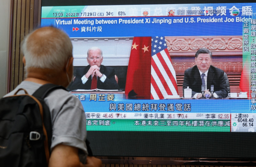  A screen displays images of Chinese President Xi Jinping and U.S. President Joe Biden, while broadcasting news about their recent call at a shopping mall in Hong Kong (photo credit: REUTERS)