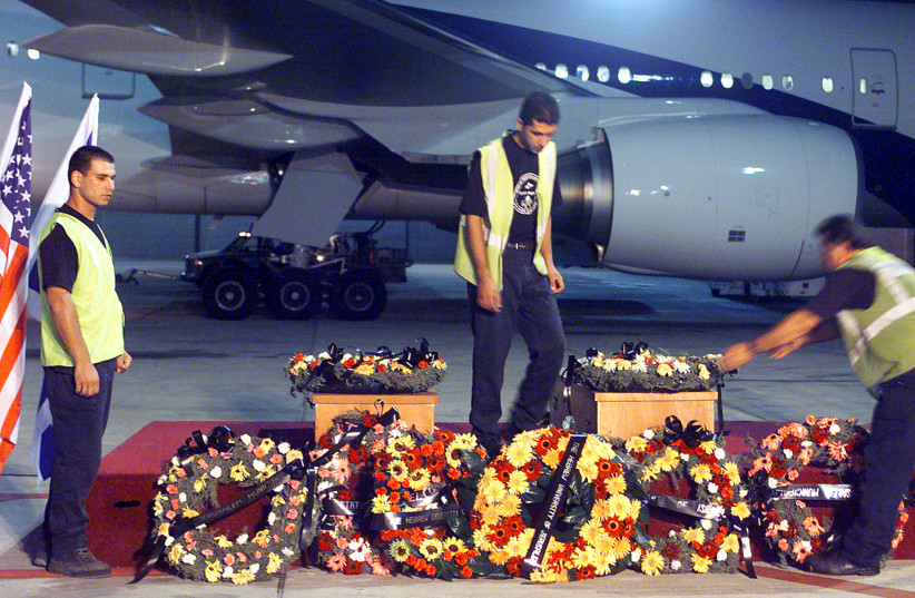  U.S. Airport workers prepare to load August 1, 2002 the coffins of Benjamin Thomas Blutstein, 25, and Jansin Ruth Coulter, 36, at a terminal of Ben Gurion airport near Tel Aviv to be shipped to the United States for burial. Both American students were killed in a bombing at the Hebrew University. (credit: REUTERS/HAVAKUK LEVISON)