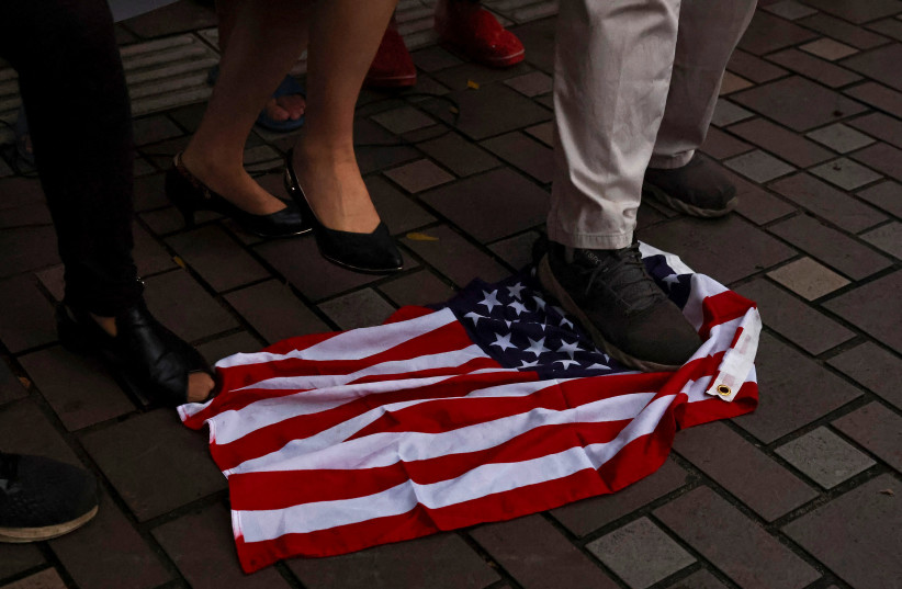  Demonstrators step on a US flag during a protest against U.S. House of Representatives Speaker Nancy Pelosi's visit, in Taipei, Taiwan August 2, 2022. (credit: REUTERS/ANN WANG)