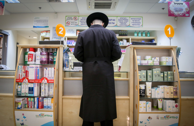  An ultra-orthodox haredi Jewish man shops for medicine at the local pharmacy in Tzfat, Northern Israel (photo credit: David Cohen/Flash90)
