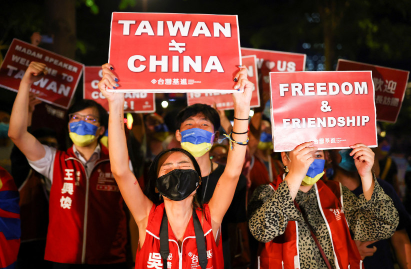  Demonstrators hold signs during a gathering in support of US House of Representatives Speaker Nancy Pelosi's expected visit, in Taipei, Taiwan August 2, 2022 (photo credit: REUTERS/ANN WANG)