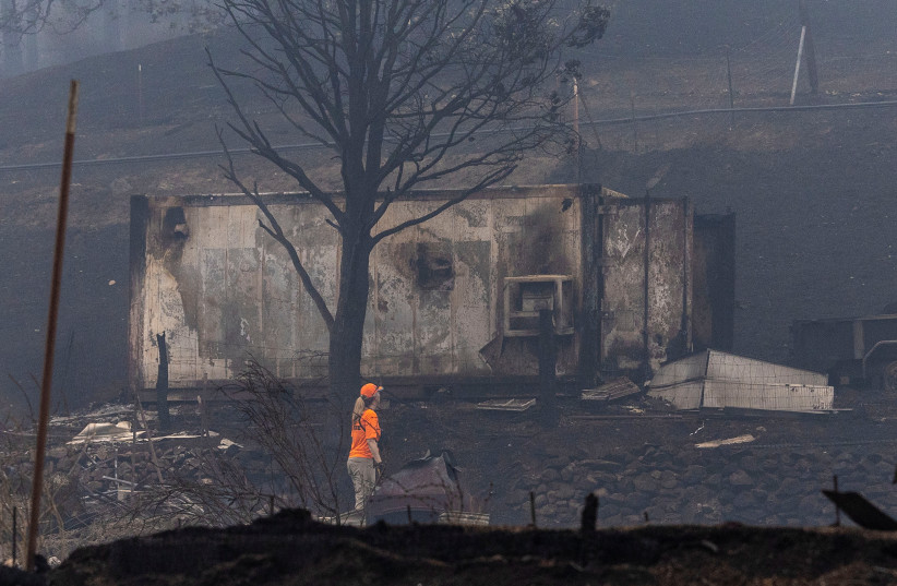  A member of a search and rescue team walks along an area destroyed by the McKinney Fire near Yreka, California, US, August 1, 2022.  (photo credit: REUTERS/CARLOS BARRIA)