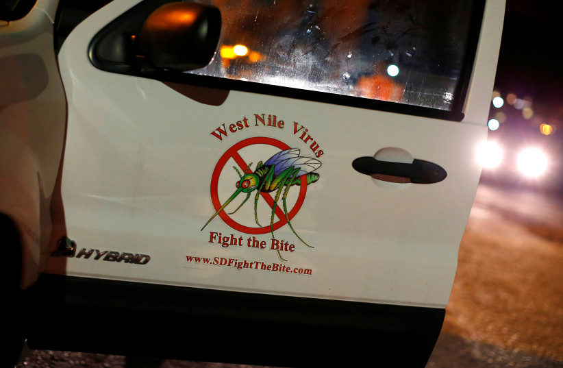  A vector control team vehicle displays a sign warning of West Nile Virus before the early morning spraying of a neighborhood due to increasing numbers of mosquitoes having tested positive for West Nile virus in San Diego, California, US May 18, 2016.  (photo credit: REUTERS/MIKE BLAKE)