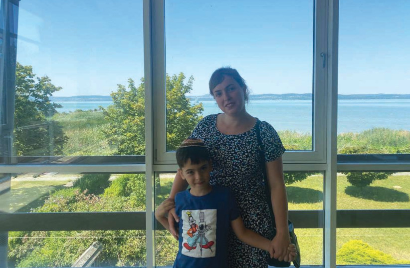  KATERINA KARVASASKA poses with her seven-year-old son Boris in the resort-turned-Jewish refugee camp in Balaton, Hungary.  (credit: TAL SPUNGIN)