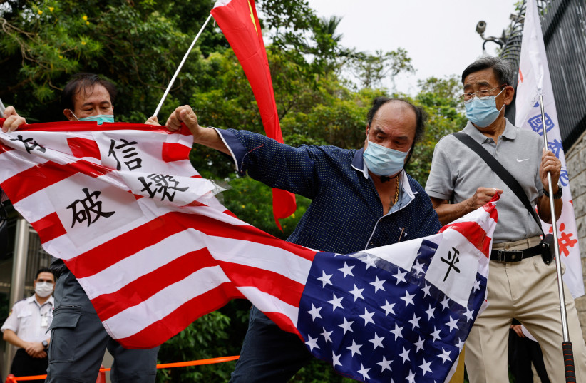  Pro-China supporters tear a US flag during a protest against US House of Representatives Speaker Nancy Pelosi's visit to Taiwan outside the Consulate General of the United States in Hong Kong, China, August 3, 2022.  (photo credit: REUTERS/TYRONE SIU)