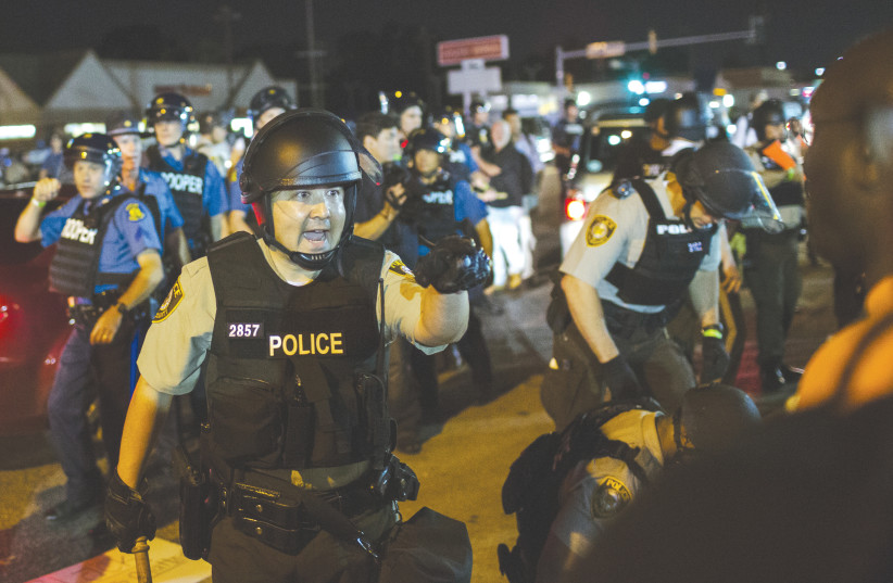  ST. LOUIS County police confront anti-police demonstrators during protests in Ferguson, Missouri, in 2015. Officers in riot gear clashed with protesters who had gathered to mark the anniversary of the police shooting of an unarmed black teen. (photo credit: LUCAS JACKSON/REUTERS)