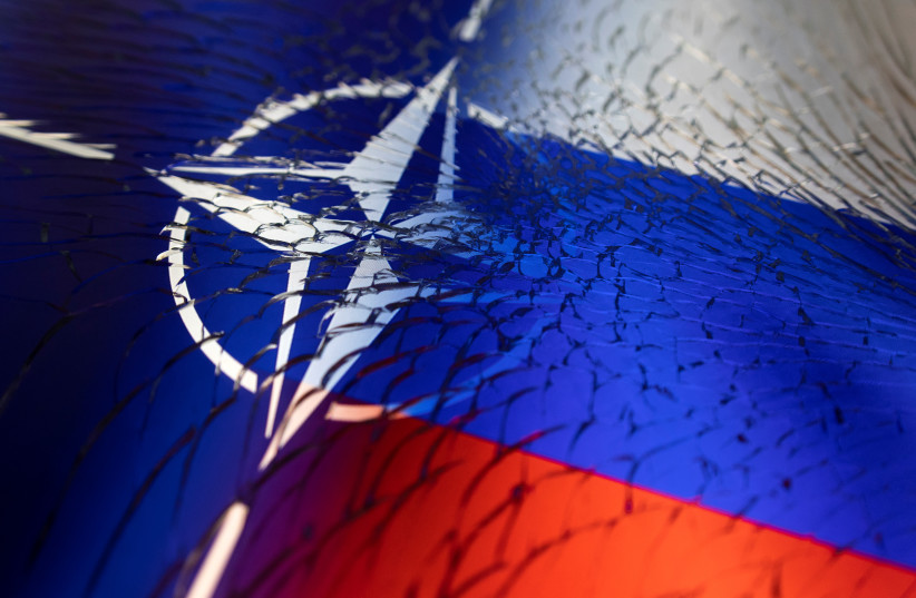 NATO and Russian flags are seen through broken glass this illustration taken April 13, 2022. (credit: REUTERS/DADO RUVIC/ILLUSTRATION)