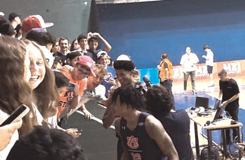  Picture of Auburn players interacting with Israeli fans  (credit: JULIA ROBBINS)