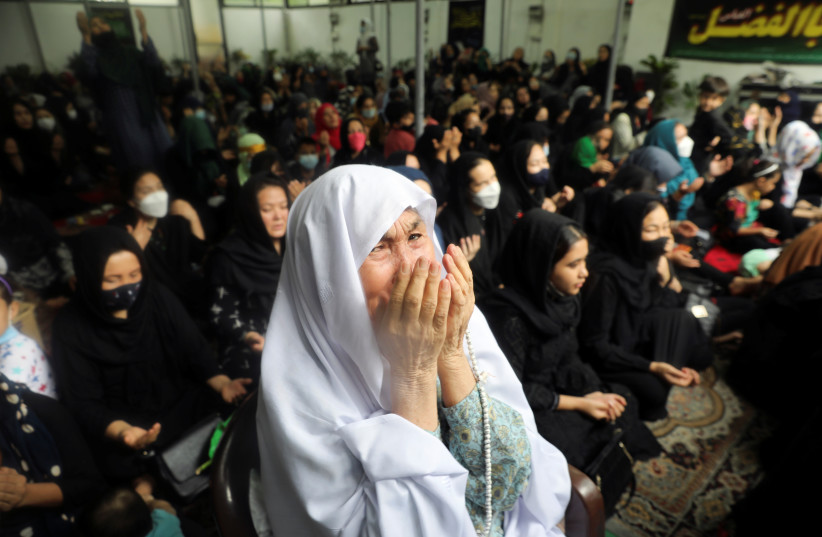 Afghan Shi'ite Muslim woman reacts as she attends a congregation to mark Ashura in New Delhi, August 20, 2021. (photo credit: REUTERS/ANUSHREE FADNAVIS)