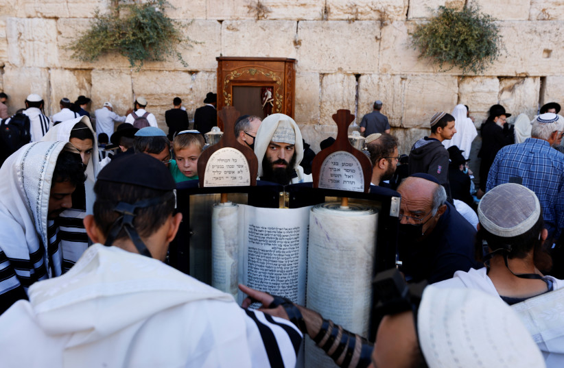 Jewish worshippers take part in prayers during Tisha B'Av, a day of fasting and lament that commemorates the date in the Jewish calendar on which it is believed the First and Second Temples were destroyed, at the Western Wall in Jerusalem's Old City July 18, 2021. (credit: REUTERS/AMIR COHEN)