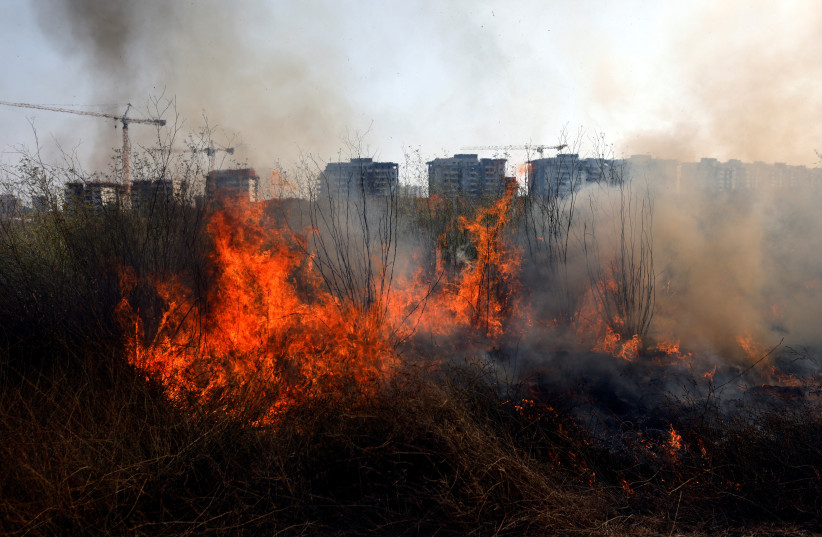  Fire burns in an area near Sderot where rockets from Gaza were fired towards Israel and Israeli Iron Dome anti-missile system were fired as well near the Israel-Gaza border August 6, 2022. (photo credit: REUTERS/AMIR COHEN)