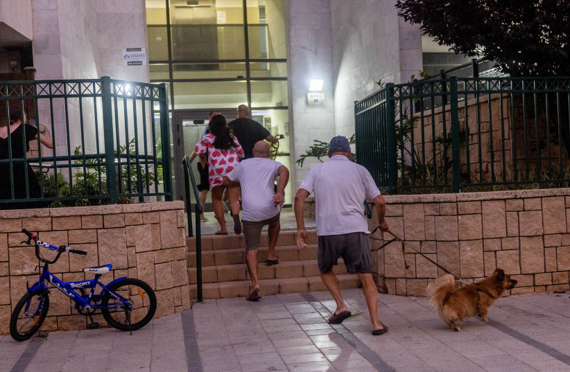  Israelis run for shelter during a rocket alert in the southern Israeli city of Ashkelon, on August 6, 2022. (photo credit: YONATAN SINDEL/FLASH90)