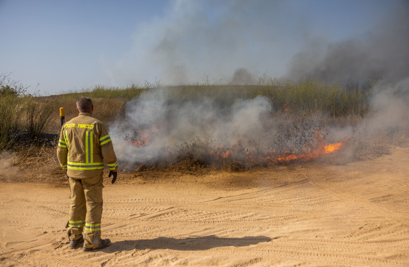  Firefighters try to extinguish a fire caused after a rocket fired from Gaza Strip hit a field near Sderot, southern Israel, on August 6, 2022. (photo credit: YONATAN SINDEL/FLASH90)