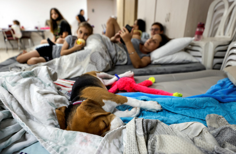  People with their dog stay in a bomb shelter following rockets fired from Gaza towards Israel, in Ashkelon, Israel August 7, 2022.  (credit: REUTERS/AMIR COHEN)