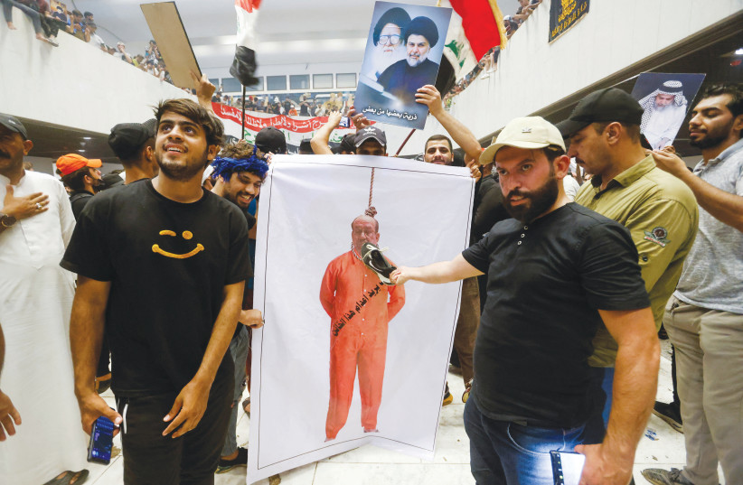  SUPPORTERS OF Iraqi Shi’ite cleric Moqtada al-Sadr hold up a banner depicting former prime minister Nouri al-Maliki, during a protest against corruption, inside the Parliament in Baghdad, on July 30.  (photo credit: AHMED SAAD/REUTERS)