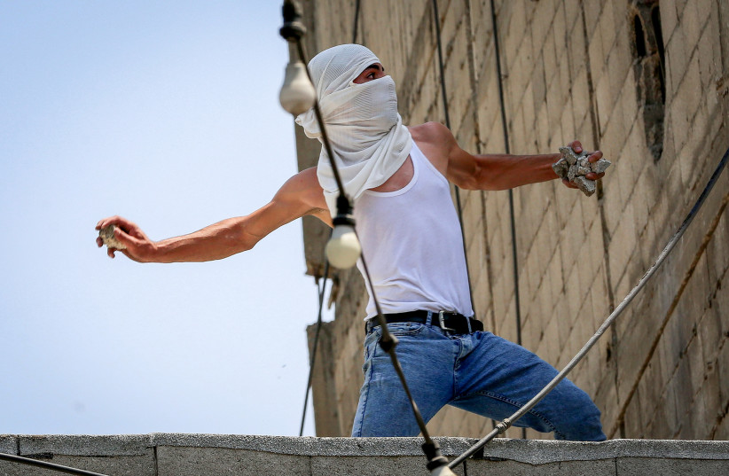 Palestinian youth clash with Israeli soldiers in the West Bank city of Hebron, August 9, 2022. (credit: WISAM HASHLAMOUN/FLASH90)