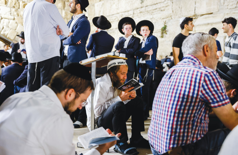  JEWISH WORSHIPERS, many of them sitting on low surfaces or the ground, mark Tisha Be’av at the Western Wall.  (credit: OLIVIER FITOUSSI/FLASH90)